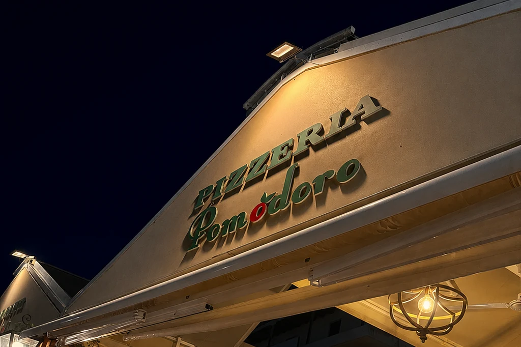 Illuminated Pizzeria Pomodoro sign at night